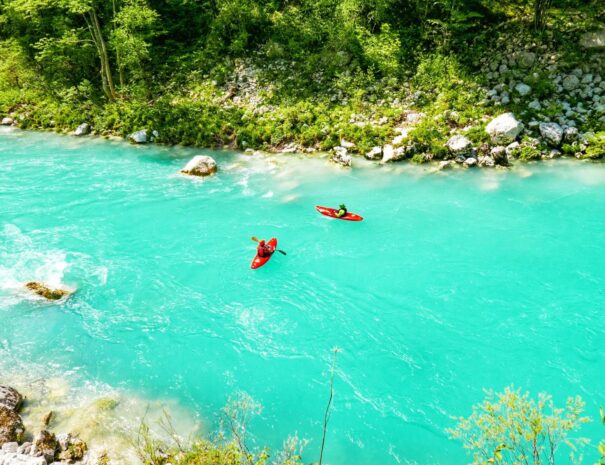 high-angle-view-of-two-red-kayaks-on-turquoise-riv-2025-03-08-08-39-02-utc1